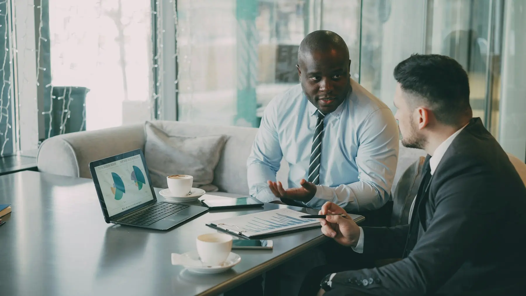 Two colleagues reviewing financial charts on a laptop