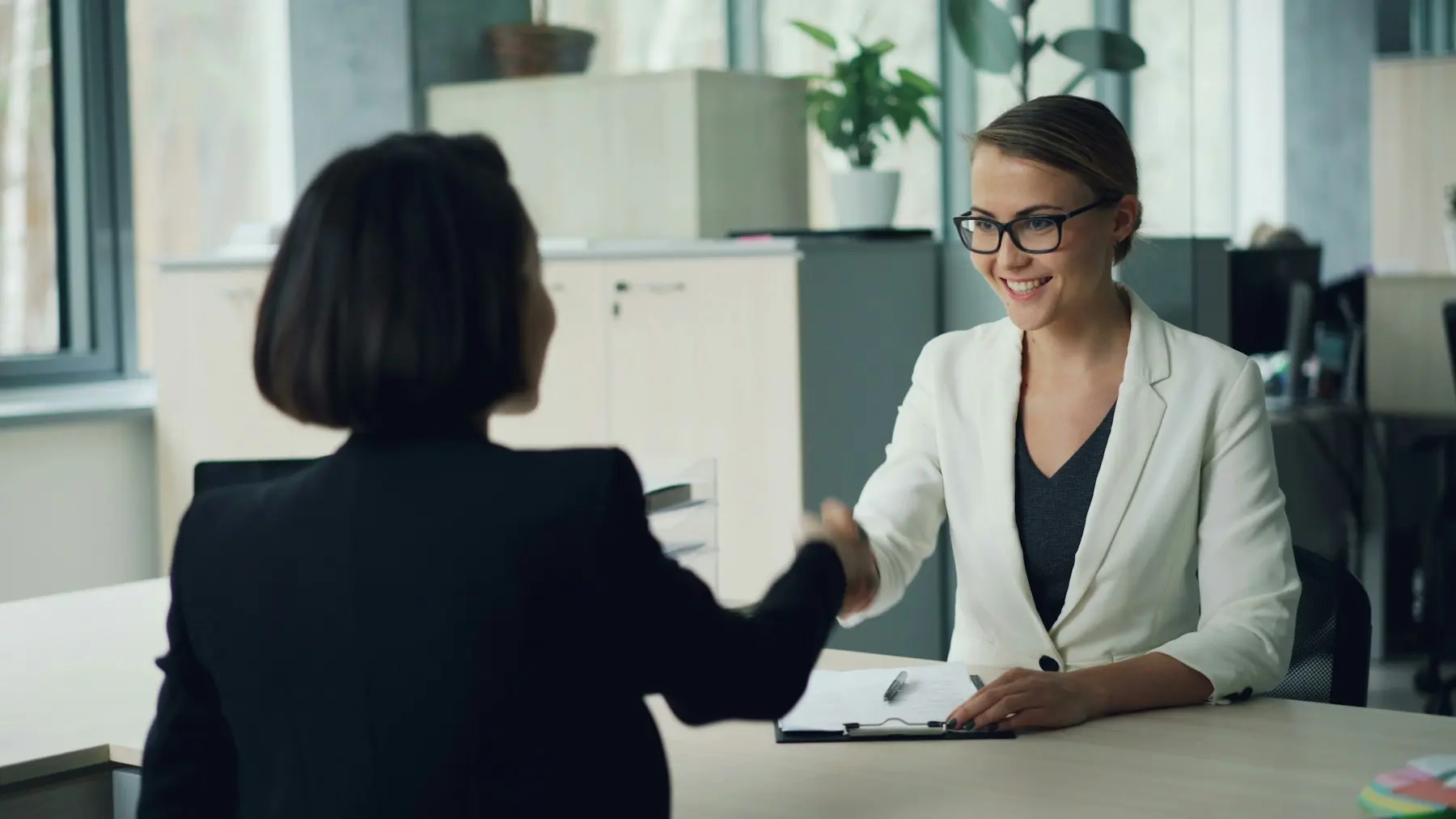 An HR manager welcoming a new colleague with a handshake